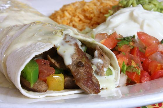 Mexican Lunch Catering. Flour tortilla burrito with beef fajitas covered in crema sauce