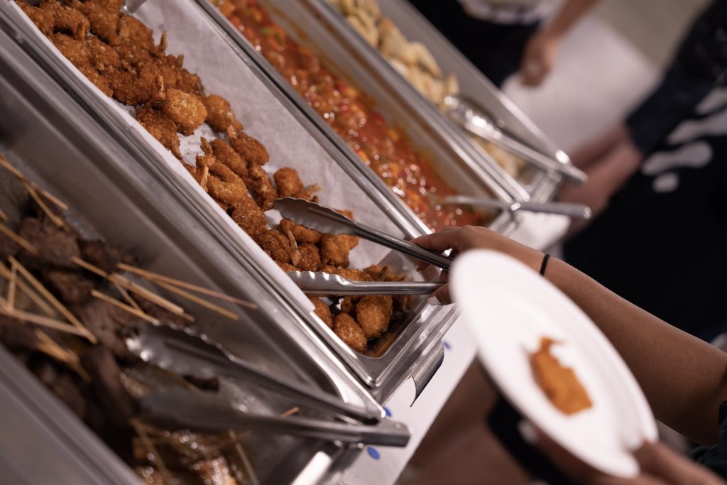 Buffet line with beef skewers and coconut shrimp by Arista Catering
