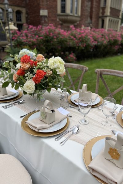 Wedding table with rose center piece and napkins on plate